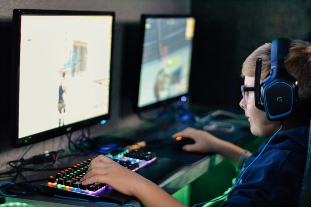 Boy gaming on a PC with headphones on.
